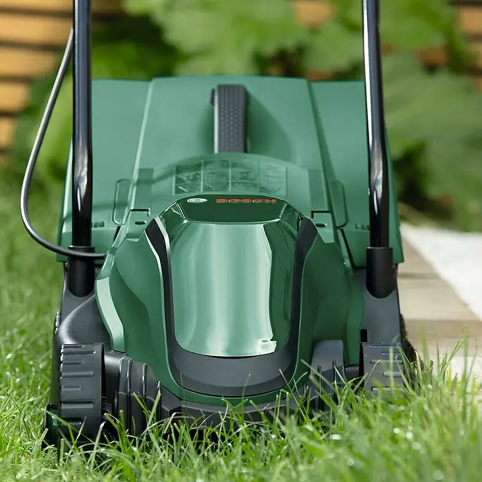 Bosch Power for All 18V Akku-Rasenmäher EasyMower 18V-32-150 - 18 V, 1 Akku, 3 Ah, Schnittbreite: 32 cm - Grüner Bosch-Rasenmäher auf Rasen. Der Rasenmäher ist der Star der Szene, bereit für die Gartenarbeit.