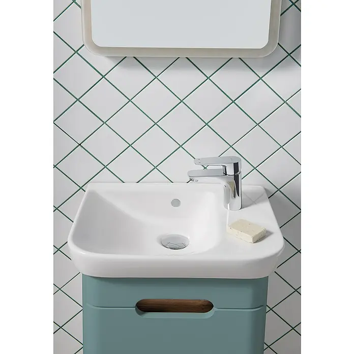 VitrA Sento Badmöbel-Set - Gesamtbreite Badmöbel: 50 cm, Fjordgrün, Matt, DIN Anschlag: Rechts - Ein elegantes Waschbecken mit einem modernen Wasserhahn und einer Seife, die auf einer stilvollen, türkisfarbenen Ablage platziert ist.