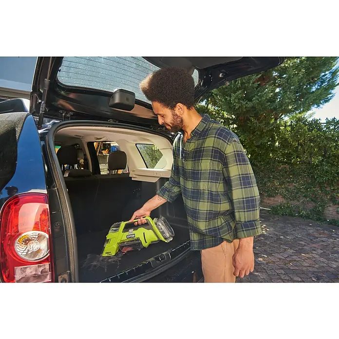 Ryobi ONE+ Akku-Nass-Trockensauger RDC18-0 - 18 V, Ohne Akku, Behältervolumen: 200 l - Ein Mann benutzt einen grünen Ryobi Swift Clean-Staubsauger, um den Kofferraum eines schwarzen Autos zu reinigen.