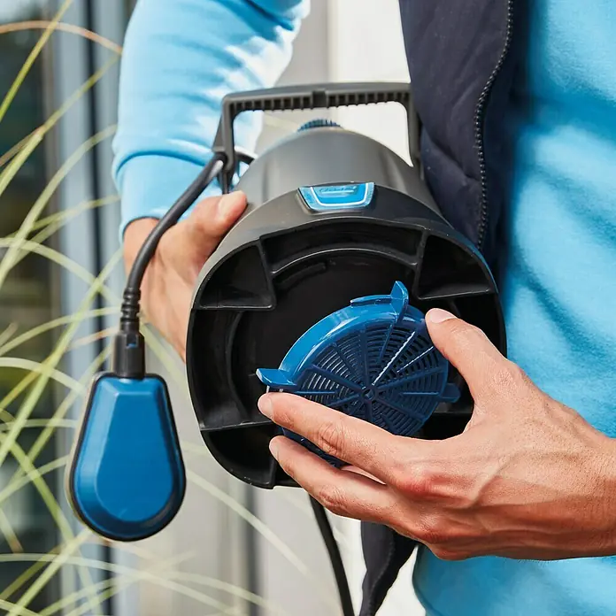 Oase ProMax Rain Regenfasspumpe ProMax Rain - 370 W, 4.000 l/h - Nahaufnahme einer schwarzen Tauchpumpe mit einem blauen Filter, die von einer Person gehalten wird.