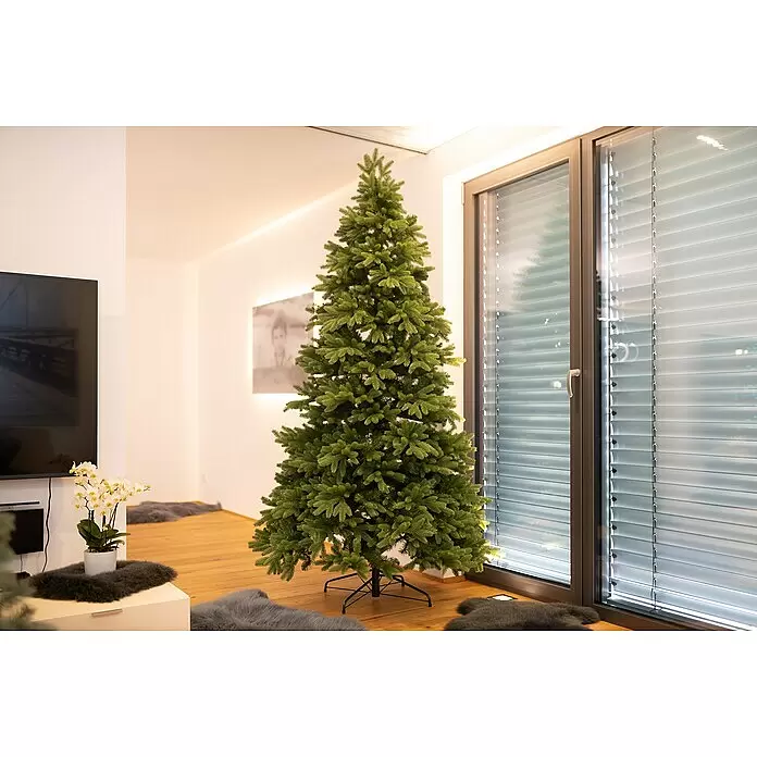 Künstlicher Weihnachtsbaum Roswell - Höhe: 240 cm, Grün, Standfuß - Großer, ungeschmückter künstlicher Weihnachtsbaum mit realistischen grünen Nadeln, drinnen aufgestellt.