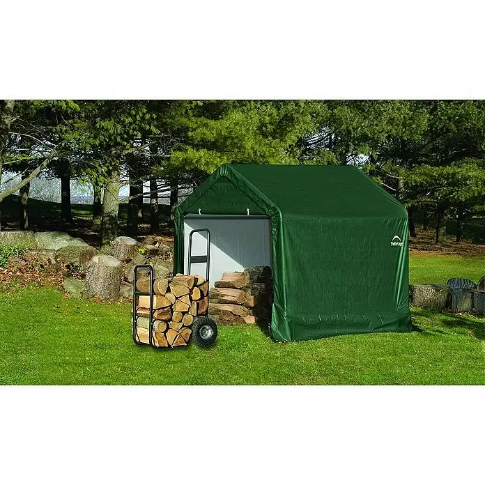 ShelterLogic Gerätehaus - Außenbreite inkl. Dachüberstand: 180 cm, Außentiefe inkl. Dachüberstand: 180 cm, Kunststoff, Grün - Grüner tragbarer Stoffschuppen für die Außenlagerung, mit gestapeltem Brennholz daneben.