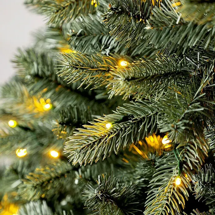 50 NRTH Künstlicher Weihnachtsbaum Vermont - Höhe: 180 cm, Grün, LED-Beleuchtung - Nahaufnahme eines dekorierten künstlichen Weihnachtsbaums mit warmweißen Lichtern. Festliche Atmosphäre und saisonale Dekoration.