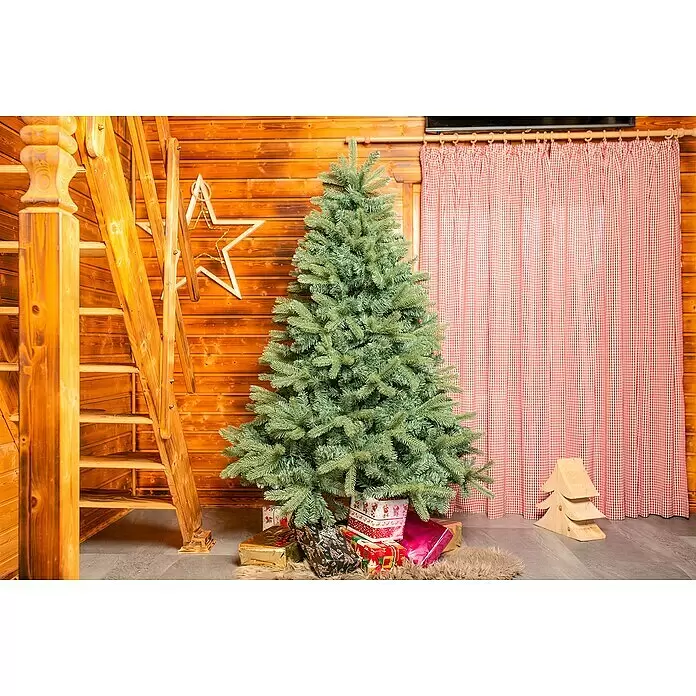 50 NRTH Künstlicher Weihnachtsbaum Vermont - Höhe: 180 cm, Grün, Standfuß - Grüner Weihnachtsbaum mit eingepackten Geschenken an der Basis, schafft eine festliche Szene in einem rustikalen Holzraum.