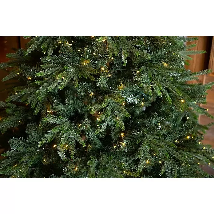 LED-Weihnachtsbaum Richmond - Höhe: 228 cm - Nahaufnahme von künstlichen grünen Weihnachtsbaumzweigen, beleuchtet mit warmen Lichterketten.