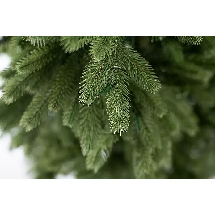 Künstlicher Weihnachtsbaum Roswell - Höhe: 150 cm, Grün, LED-Beleuchtung - Nahaufnahme eines grünen Kunst-Weihnachtsbaumzweigs mit warmweißen LED-Lichtern, ideal für Feiertagsdeko.