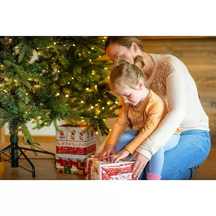 LED-Weihnachtsbaum Richmond - Höhe: 228 cm - Mutter und Kind packen ein Weihnachtsgeschenk neben einem beleuchteten Weihnachtsbaum aus.