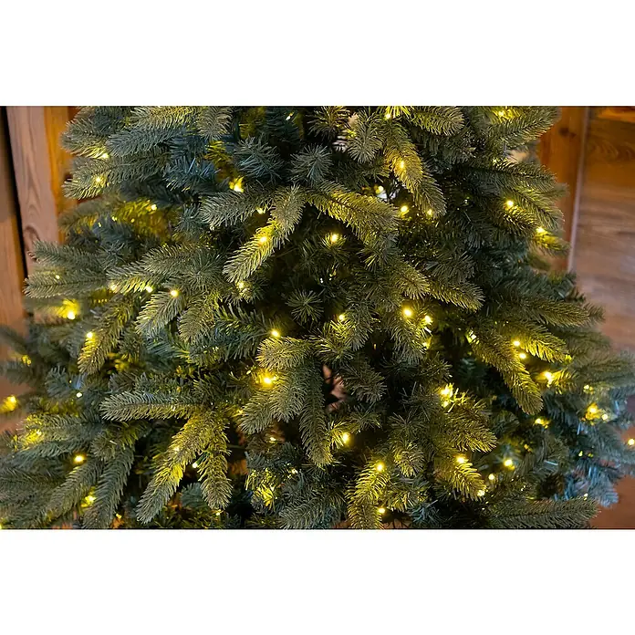 50 NRTH Künstlicher Weihnachtsbaum Vermont - Höhe: 180 cm, Grün, LED-Beleuchtung - Nahaufnahme eines geschmückten Weihnachtsbaums mit warmweißen Lichtern, die eine festliche und gemütliche Atmosphäre schaffen.