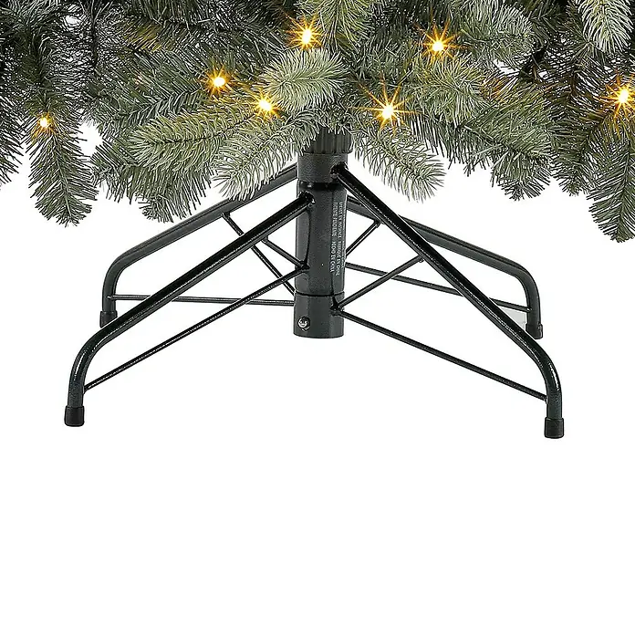 50 NRTH Künstlicher Weihnachtsbaum Vermont - Höhe: 180 cm, Grün, LED-Beleuchtung - Detailaufnahme eines künstlichen Weihnachtsbaums mit Fokus auf den schwarzen Metallständer und warmen Lichtern.