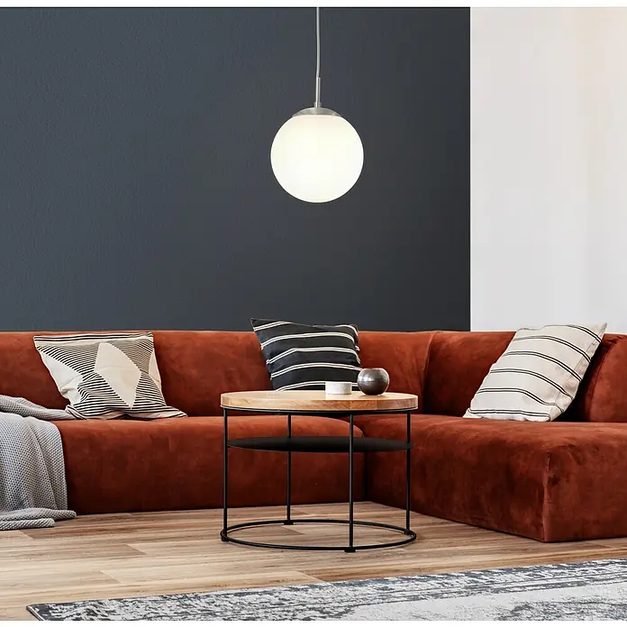 Eglo Pendelleuchte rund Rondo - Durchmesser: 200 mm - Das Foto zeigt ein modernes Wohnzimmer mit einer auffälligen, runden Hängelampe, die über einem Beistelltisch und einem orangefarbenen Sofa hängt.