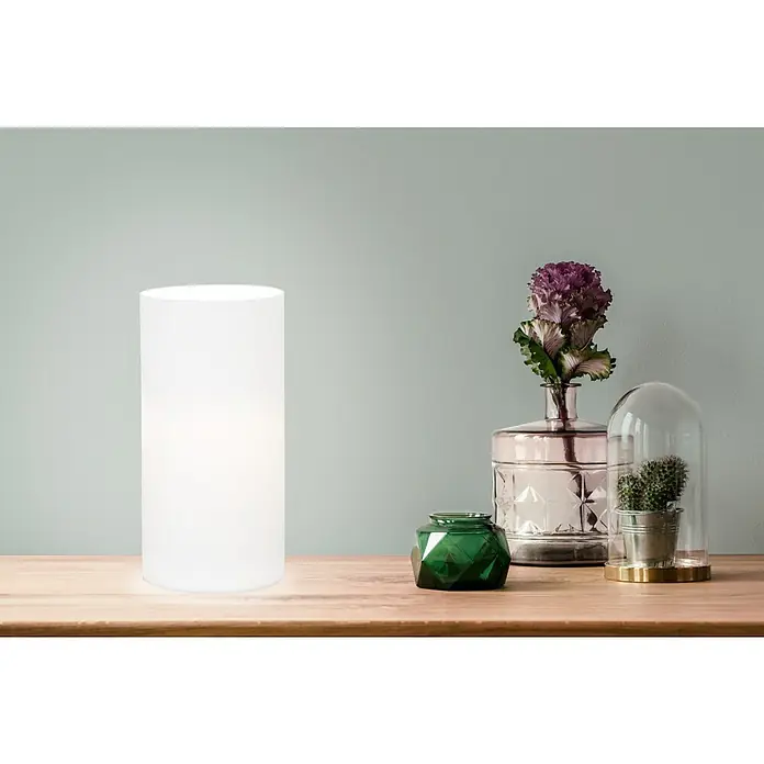 Eglo Geo Tischleuchte rund - 60 W, Ø x H: 100 mm x 20 cm, Weiß, Weiß, E14 - Das Bild zeigt eine moderne, zylindrische Tischleuchte, die ein sanftes Licht ausstrahlt, auf einem Holztisch neben dekorativen Vasen.