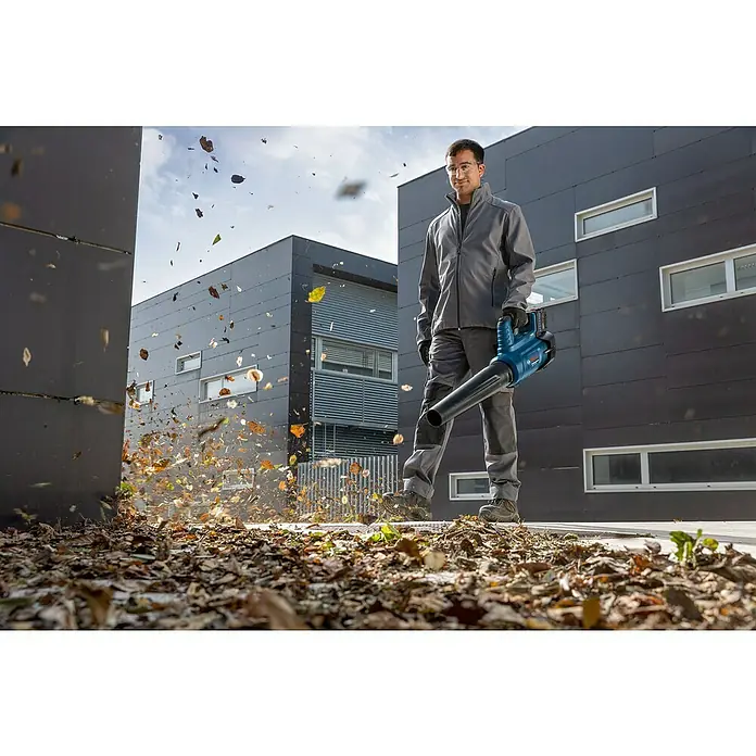 Bosch Professional AMPShare 18V Akku-Gebläse GBL 18V-750 - 18 V, Ohne Akku, Blasgeschwindigkeit: 198 km/h - Ein Mann benutzt einen Bosch Laubbläser, um Blätter zu entfernen. Der Laubbläser ist blau und schwarz und bläst die Blätter weg.