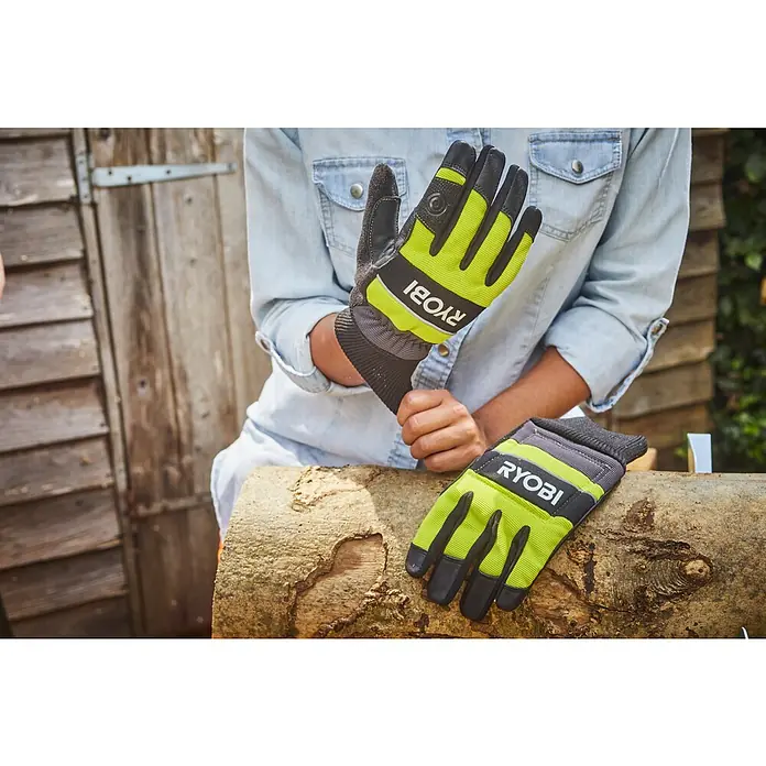 Ryobi Schutzhandschuhe RAC258 - XL - Ein Paar Ryobi-Arbeitshandschuhe in Grün und Schwarz, die auf einem Holzstamm liegen. Die Handschuhe sind ideal für Garten- und Bauarbeiten.