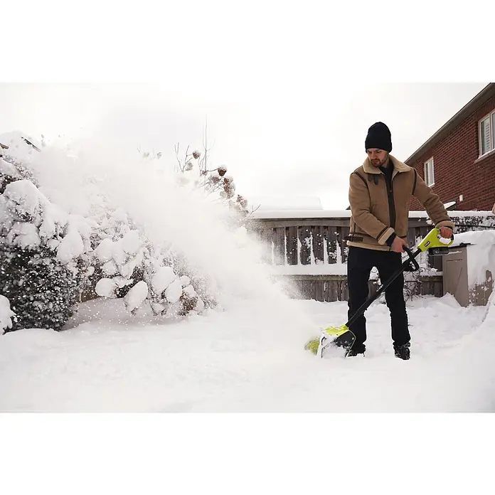 Ryobi ONE+ Akku-Schneefräse RY18ST25A-0 - 18 V, Ohne Akku, Arbeitsbreite: 25 cm - Mann mit Ryobi Schneefräse beim Schnee räumen.