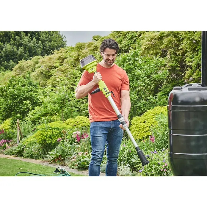 Ryobi ONE+ Akku-Regenfasspumpe RY18STPA-0 - Max. Fördermenge: 3.360 l/h - Ein Mann im Garten hält einen grünen Ryobi-Unkrautvernichter in der Hand, mit einem Gartenteich und üppigem Grün im Hintergrund.