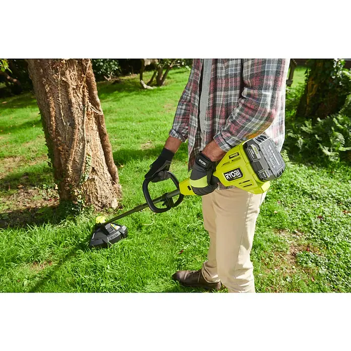 Ryobi ONE+HP Akku-Rasentrimmer RY18LTX38A-0 - 18 V, Li-Ionen, Ohne Akku - Eine Person trimmt Gras mit einem Ryobi Akku-Rasentrimmer im Garten, mit Fokus auf das Werkzeug und seine Anwendung im Freien.