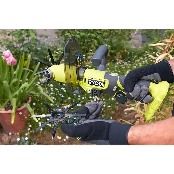 Ryobi ONE+ Akku-Bodenhacke RY18HCA-0 - 18 V, Ohne Akku - Nahaufnahme eines Ryobi-Gartenwerkzeugs mit auswechselbaren Aufsätzen, das für verschiedene Gartenarbeiten verwendet werden kann.