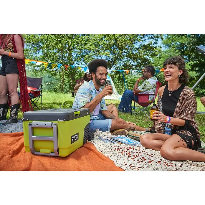 Ryobi ONE+ Akku-Kühlbox Hybrid RY18CB23A-0 - L x B x H: 72,5 x 42 x 49,5 cm, Fassungsvermögen: 23 l - Menschen genießen ein Festival mit einer gelben Kühlbox von Ryobi. Sie sitzen auf einer Decke und trinken.