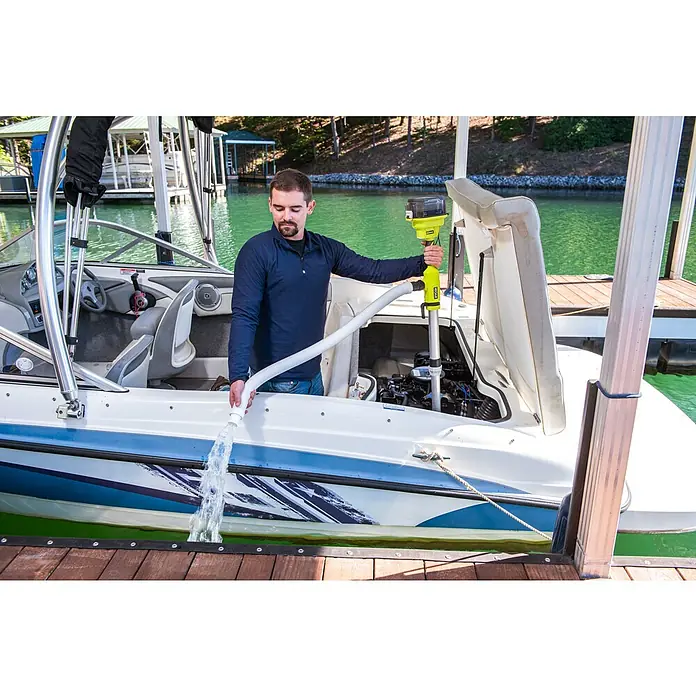 Ryobi ONE+ Akku-Regenfasspumpe RY18STPA-0 - Max. Fördermenge: 3.360 l/h - Mann pumpt mit einer Akku-Wasserpumpe Wasser aus einem Boot am Bootssteg, das grüne Ryobi-Gerät im Einsatz.