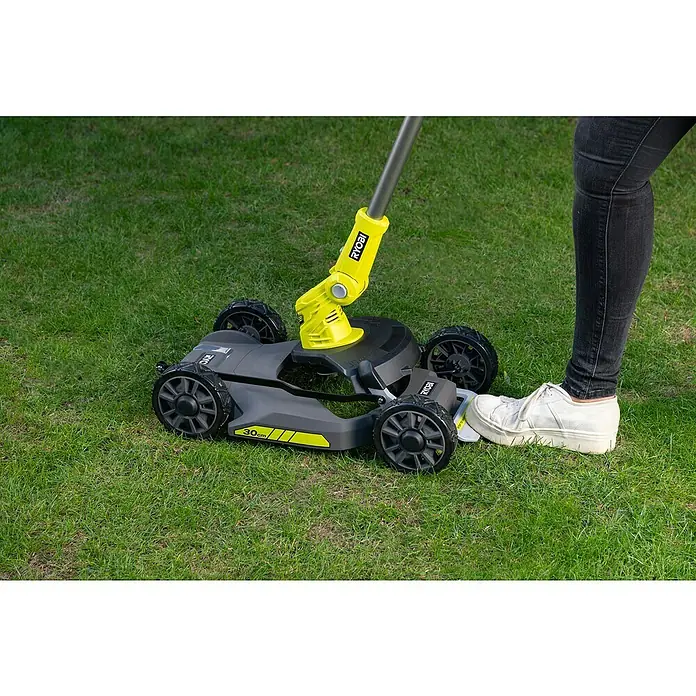 Ryobi ONE+ Akku-Rasenmäher RY18LMC30A-0 - 18 V, Ohne Akku, Schnittbreite: 30 cm - Ein Ryobi Rasenmäher steht auf einem Rasen, daneben ein Bein mit einem weißen Schuh.