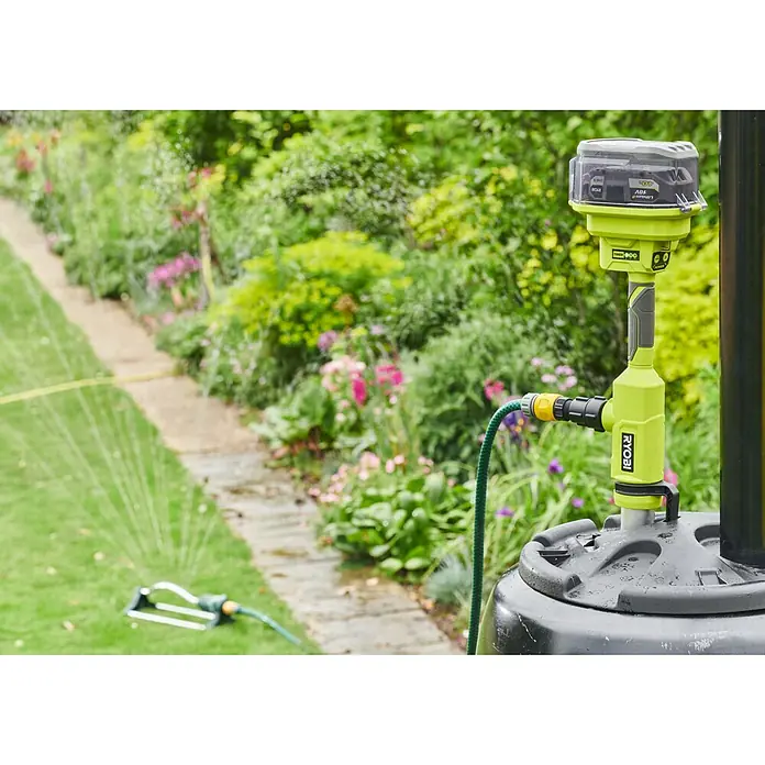 Ryobi ONE+ Akku-Regenfasspumpe RY18STPA-0 - Max. Fördermenge: 3.360 l/h - Das RYOBI ONE+ Bewässerungssystem mit Akku und angeschlossenem Schlauch vor einem grünen Garten. Ideal für die Gartenbewässerung.