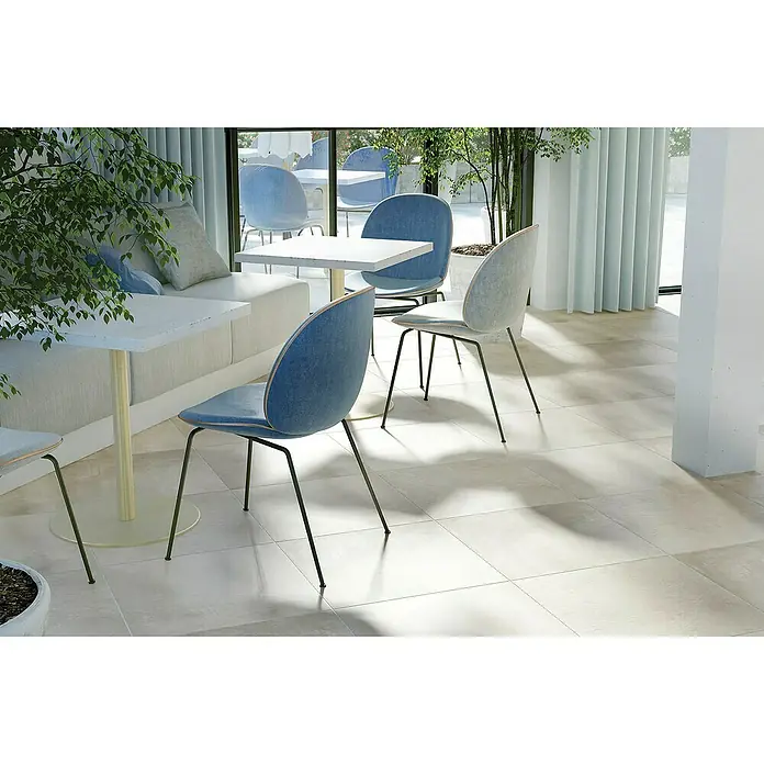 Queens Feinsteinzeugfliese - 79,8 x 79,8 cm, Weiß, Matt - Blick auf moderne Esszimmerstühle mit blauen Sitzflächen und schwarzen Beinen, die um einen weißen Tisch herum in einem stilvollen Interieur stehen.