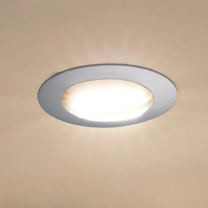 Eglo LED-Einbauleuchte Pineda rund - 6 W, L x B x H: 8,4 x 8,4 x 4 cm, Chrom, Warmweiß, Dimmbarkeit: Dimmbar - Nahaufnahme einer runden, versenkten Deckenleuchte mit silbernem Rahmen, die ein warmes, diffuses Licht in einem Raum abstrahlt.