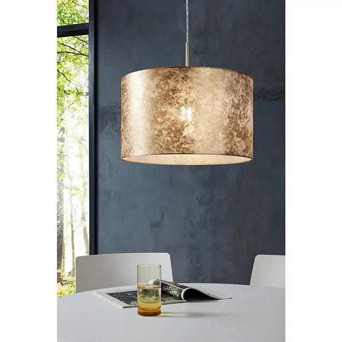 Eglo Viserbella PendelleuchteHöhe: 110 cm - Eine goldene Hängelampe mit zylindrischem Schirm über einem Tisch mit Glas und Zeitschrift. Elegantes Design für moderne Interieurs.