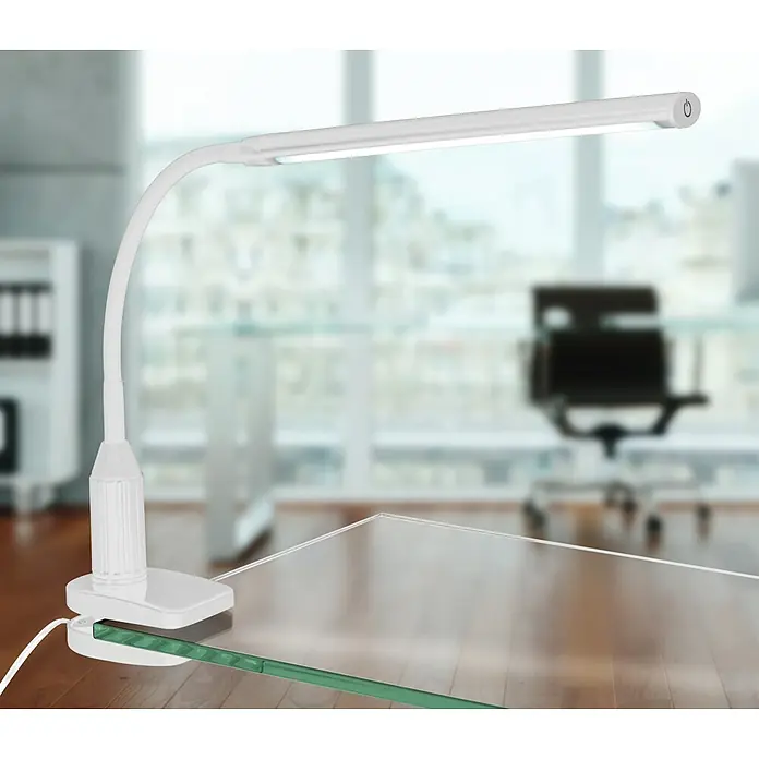 Eglo LED-Klemmleuchte Laroa - L x B x H: 45 x 6,5 x 27,5 cm - Nahaufnahme einer weißen LED-Schreibtischlampe mit Klemme auf einem transparenten Tisch mit verschwommenem Bürohintergrund.
