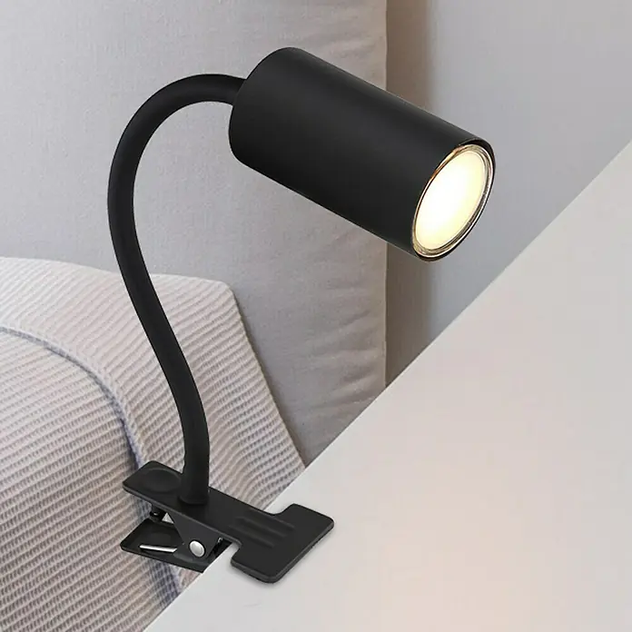 Globo Robby Klemmleuchte25 W, L x B x H: 29 x 10 x 41,5 cm, Farbe Gehäuse: Schwarz, GU10 - Eine schwarze Klemmleuchte mit flexiblem Hals leuchtet auf einem weißen Nachttisch, perfekt zum Lesen im Bett.
