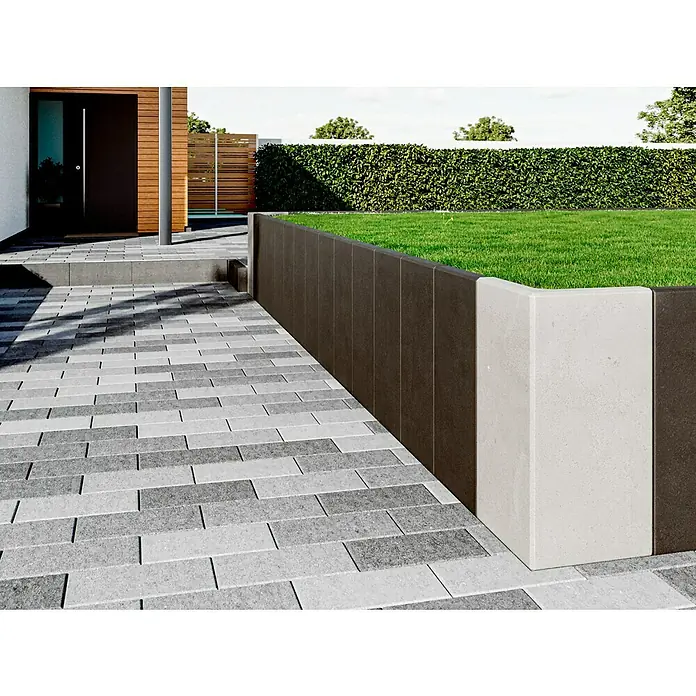 Diephaus L-Stein - 100 cm, 40 cm, Stärke: 7 cm, Anthrazit - Außenaufnahme mit einem Pflasterweg, der zu einem modernen Haus führt, mit einem erhöhten Gartenbeet mit Rasen.