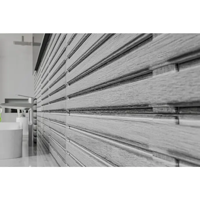Wandfliese Spa Perla Dekor - 30 x 90 cm, Grau, Matt - Detailaufnahme einer grauen, holzähnlichen Wandverkleidung im Badezimmer mit Ablagefläche und Armatur. Modernes Design.