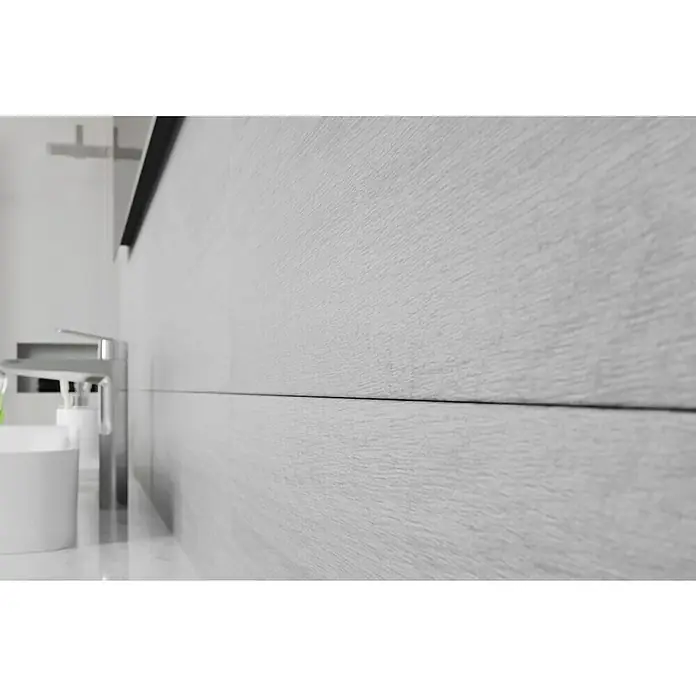 Wandfliese Spa Perla Base - 30 x 90 cm, Grau, Matt - Nahaufnahme einer modernen Waschbeckenarmatur mit einem weißen Becher und einer Seifenpumpe vor einer hellgrauen Holzvertäfelung.
