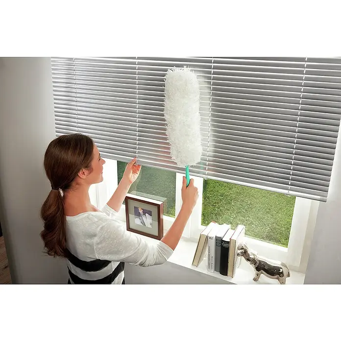 Leifheit Staubwedel Duster XL - Länge: 38 cm, Mikrofaser - Frau reinigt Jalousien mit einem Staubwedel. Der Staubwedel ist flauschig und hat einen grünen Griff.
