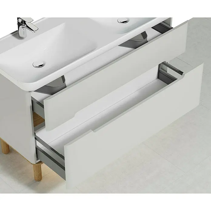 VitrA Sento Badmöbel-Set - 130 cm, Hellgrau, Ohne Wäschekorb - Ein moderner Waschtischunterschrank in Weiß mit zwei offenen Schubladen und hellen Holzfüßen. Das Waschbecken ist elegant und formschön gestaltet.