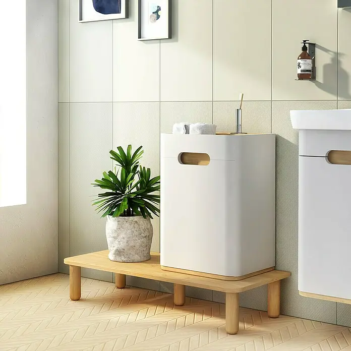 VitrA Sento Halbhochschrank - B x T x H: 40 x 29,5 x 58 cm, Hellgrau, DIN Anschlag: Links - Ein stilvolles Badezimmer mit einem weißen Badezimmerschrank, der auf einem Holzsockel steht, neben einer grünen Pflanze im Topf.