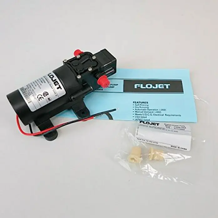 Mini bomba de aire Flojet - Apto para: Bombas de achique - La imagen muestra una bomba FLOJET, conocida por su capacidad de autocebado y funcionamiento en seco, junto con accesorios.