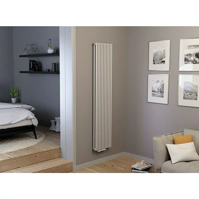 Ximax Raumheizkörper Gamba Slim Duplex - B x H: 505 x 1.800 mm, Wärmeleistung bei Vorlauftemperatur von 75 °C (D: 50): 1.424 W - Ein modernes Wohnzimmer mit einem schlanken, weißen Heizkörper an der Wand, der Eleganz und Funktionalität vereint. Helle Holzfußböden runden das Design ab.