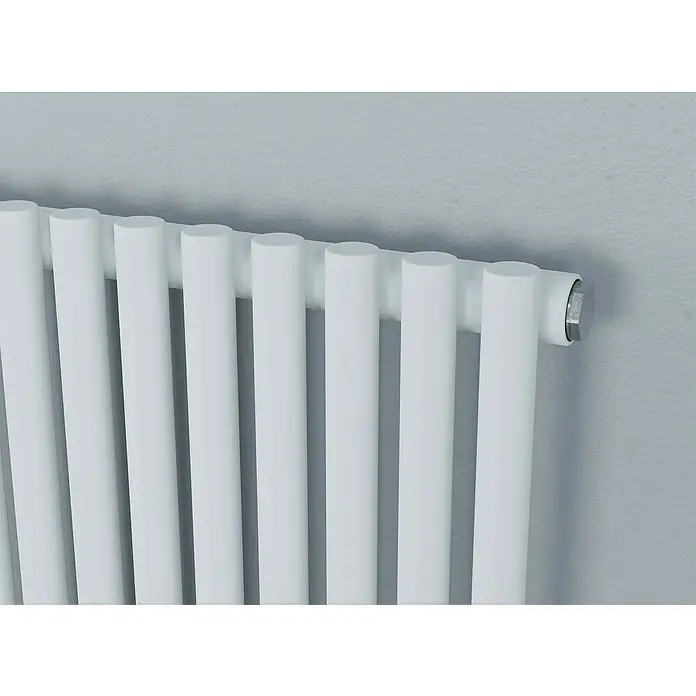 Ximax Raumheizkörper Gamba Slim - B x H: 505 x 1.800 mm, Wärmeleistung bei Vorlauftemperatur von 75 °C (D: 50): 1.012 W - Nahaufnahme eines modernen, weißen Heizkörpers mit vertikalen Rohren und einem glänzenden, silbernen Abschlussstück vor einer hellgrauen Wand.