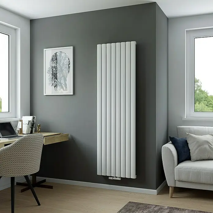 Ximax Designheizkörper NovusB x H: 55,5 x 180 cm, Wärmeleistung bei Vorlauftemperatur von 75 °C (D: 50): 1.303 W, Weiß - Ein vertikaler Heizkörper in einem modern eingerichteten Raum mit Schreibtisch und Sofa. Der Heizkörper ist weiß und schlank.