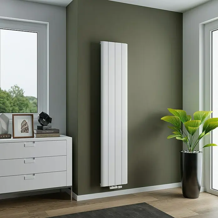 Ximax Designheizkörper Trigo - B x H: 375 x 1.800 mm, Wärmeleistung bei Vorlauftemperatur von 75 °C (D: 50): 768 W, Weiß - Elegantes, vertikales Heizpaneel in Weiß vor einer olivgrünen Wand. Das Design ist modern und platzsparend, ideal für stilvolle Wohnräume.
