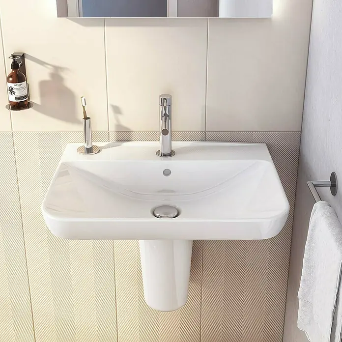 VitrA Sento Waschtisch - 63 x 48,5 cm, Weiß - Nahaufnahme eines weißen Waschbeckens mit Armatur, Seifenspender und Handtuchhalter in einem modernen Badezimmer.