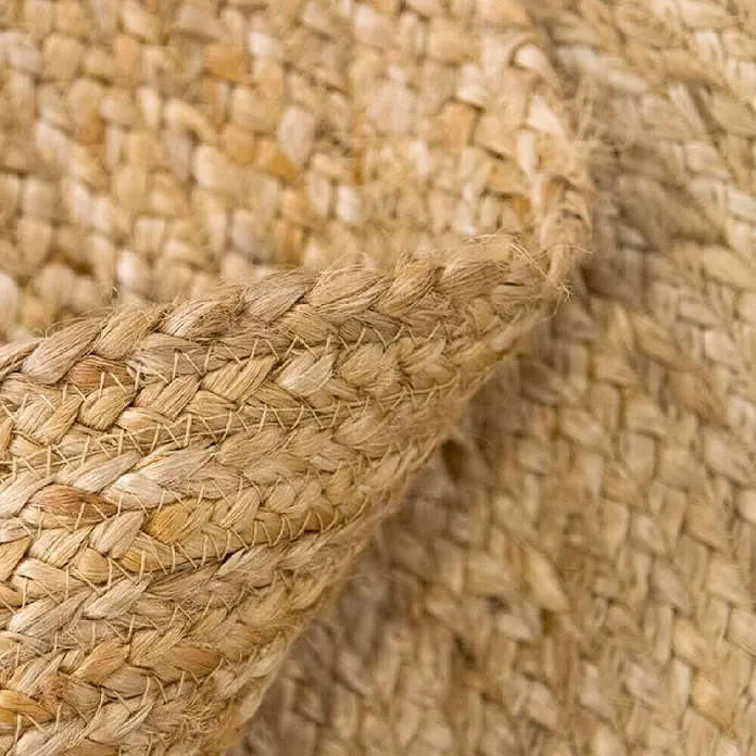 Alfombra textil plana Nazar - Beige, 150 cm - Primer plano de una alfombra de yute tejida que muestra intrincados diseños y texturas. El material natural añade calidez y encanto rústico.