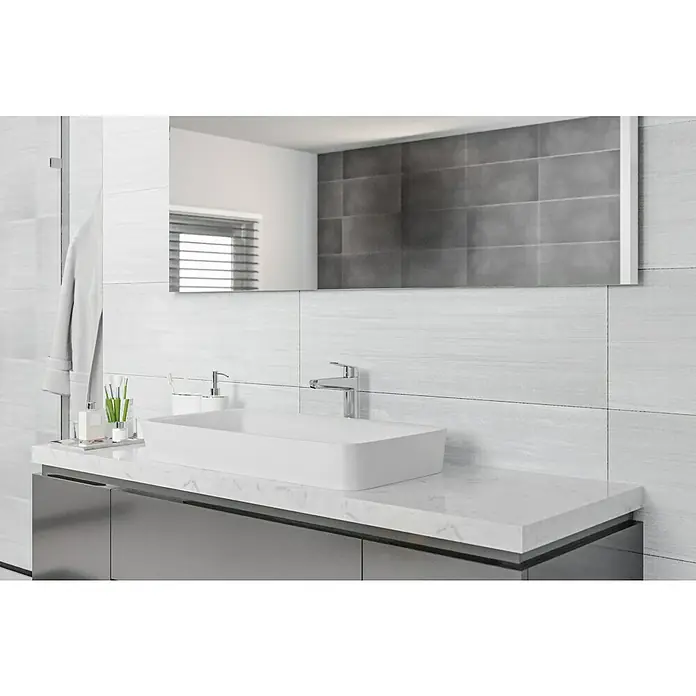 Wandfliese Layers Base Gris - 30 x 90 cm, Grau, Matt - Ein elegantes Badezimmer mit einem modernen Waschbecken auf einer Marmorplatte und einem großen Spiegel, der den Raum optisch vergrößert.