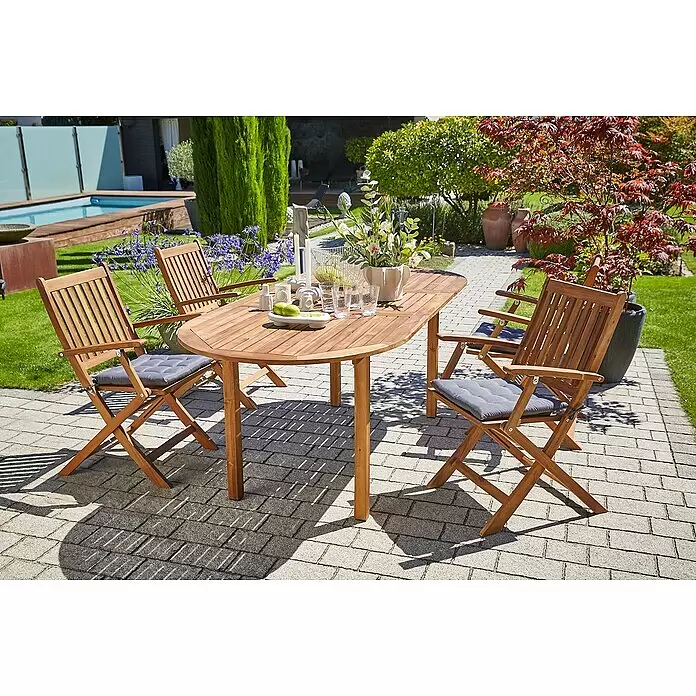 Sunfun Sitzkissen Nils - L x B x H: 40 x 40 x 4 cm, Anthrazit, 100% Polyester - Ovaler Gartentisch aus Holz mit vier passenden Klappstühlen und grauen Kissen auf einer gepflasterten Terrasse.