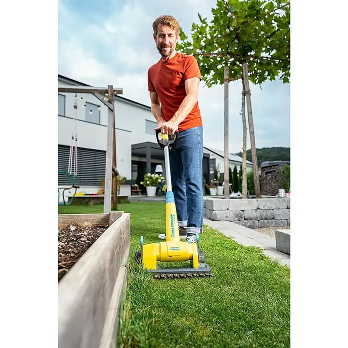 Gloria MultiBrush Grasscherenaufsatz FineCut - Passend für: MultiBrush PLUS Geräte - Mann benutzt GLORIA MultiBrush zur Rasenpflege. Das Gerät ist gelb und hilft, den Rasen sauber und gepflegt zu halten.