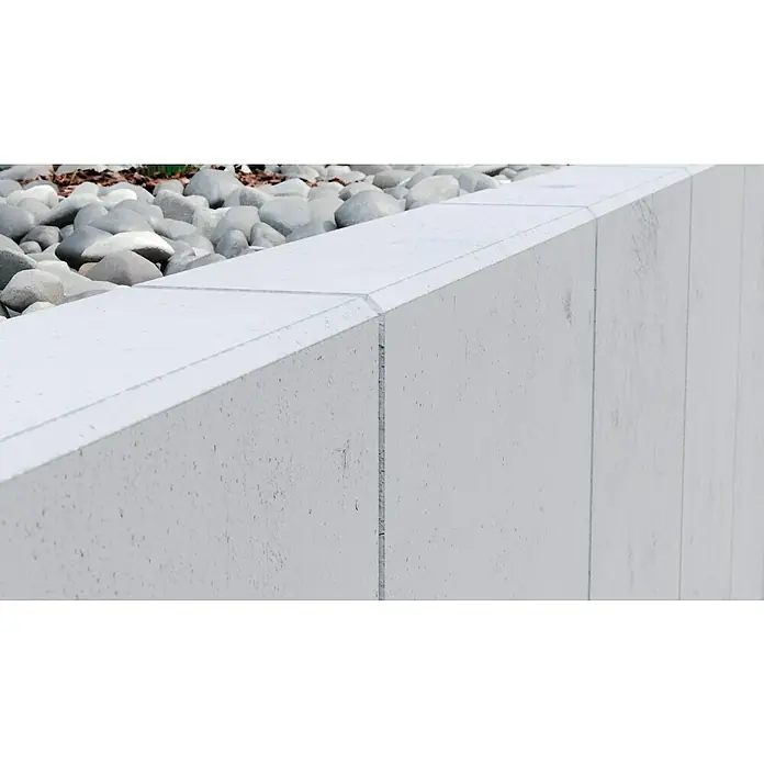 Diephaus L-Stein - 155 cm, 50 cm, Stärke: 12 cm, Grau - Nahaufnahme einer Betonmauer mit Steinen im Hintergrund, die die architektonische Struktur und Textur des Betonprodukts hervorhebt.