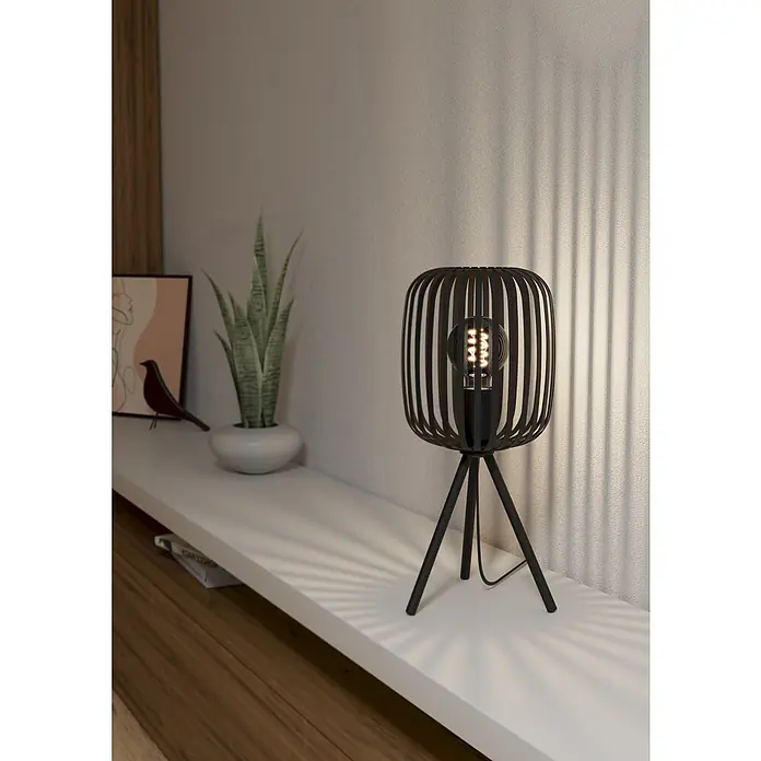Eglo Romazzina Tischleuchte - 40 W, Schwarz, E27 - Nahaufnahme einer dekorativen, schwarzen Lampe mit Edison-Glühbirne, die auf einem weißen Regal steht.