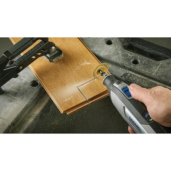 Dremel Akku-Multifunktionswerkzeug 8240-3/45 - 12 V, 1 Akku, 2 Ah, Inkl. 3 Aufsätzen und 45 Zubehören - Ein Dremel Multifunktionswerkzeug schneidet ein Holzbrett auf einer Werkbank. Es ist ein vielseitiges Werkzeug für verschiedene Projekte.