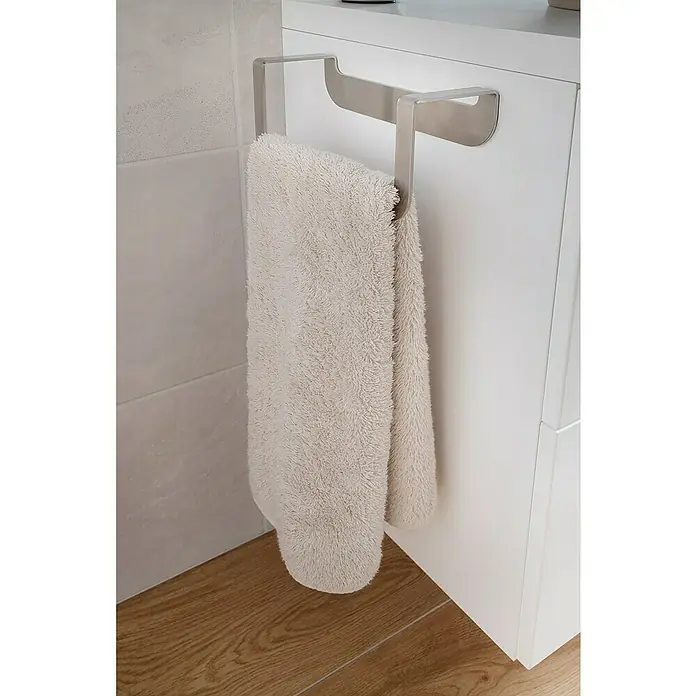 Camargue Antwerpen Handtuchhalter - Breite: 23 cm, Edelstahl, Matt - Ein weiches, cremefarbenes Handtuch hängt elegant an einem modernen, minimalistischen Handtuchhalter an einem weißen Badezimmerschrank.